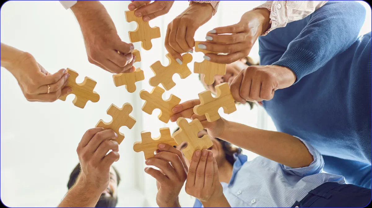 Many hands fitting puzzle pieces together